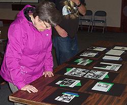 Audience member studying materials relating to early medical facilities in Lakewood.